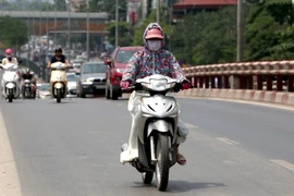 Thời trang bịt kín được nhiều người sử dụng hữu hiệu mỗi khi phải di chuyển trên đường giữa trời nắng nóng (ảnh chụp ngày 31/7/2017). (Ảnh: Thành Đạt/TTXVN)