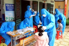 Lực lượng y tế lấy mẫu xét nghiệm cho toàn bộ học sinh trường Tiểu học Nguyên Xá (Thái Bình), nơi ghi nhận 6 học sinh dương tính với SARS- CoV-2. (Ảnh: Thế Duyệt/TTXVN)