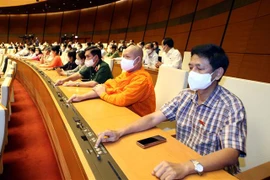 Đại biểu Quốc hội biểu quyết thông qua Nghị quyết về Chương trình xây dựng luật, pháp lệnh năm 2022, điều chỉnh Chương trình xây dựng luật, pháp lệnh năm 2021. (Ảnh: Phạm Kiên/TTXVN)