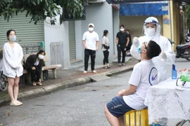 Nhân viên y tế lấy mẫu xét nghiệm COVID-19 cho người dân xã Ninh Hiệp (huyện Gia Lâm), ngày 2/11. (Ảnh: Minh Quyết/TTXVN)