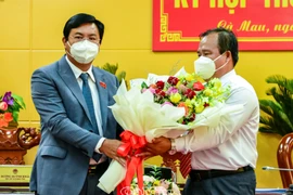 Ông Nguyễn Tiến Hải, Ủy viên Trung ương Đảng, Bí thư Tỉnh ủy, Chủ tịch HĐND tỉnh Cà Mau, tặng hoa chúc mừng ông Nguyễn Minh Luân (bên phải) được bầu giữ chức Phó Chủ tịch UBND tỉnh Cà Mau nhiệm kỳ 2021-2026. (Nguồn: VGP)