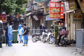 Lực lượng công nhân vệ sinh thu dọn rác thải tại khu vực phong tỏa phường Phú Đô, quận Nam Từ Liêm (Hà Nội). (Ảnh: Tuấn Đức/TTXVN)
