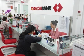 Khách hàng giao dịch tại Ngân hàng TechcomBank. (Ảnh: Thanh Tân/TTXVN)