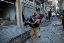 Chuyển cậu bé bị thương sau đợt không kích của Israel xuống thành phố Khan Younis, Dải Gaza ngày 19/10/2023. (Ảnh: THX/TTXVN)