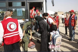 Nhân viên Hội Trăng lưỡi liềm Đỏ Syria hỗ trợ người dân sơ tán khỏi Daraya tới trại tị nạn Herjelleh ở gần Damascus. (Nguồn: EPA/TTXVN)