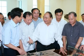 Thủ tướng Nguyễn Xuân Phúc xem mẫu than giếng khoan SH11 thuộc Đề án thăm dò than khu Nam Thịnh, huyện Tiền hải, Thái Bình. (Ảnh: Thống Nhất/TTXVN)