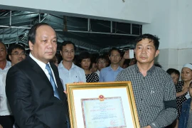 Bộ trưởng, Chủ nhiệm Văn phòng Chính phủ Mai Tiến Dũng đến viếng và trao Huân chương Bảo vệ Tổ quốc hạng Nhất truy tặng Thiếu úy phi công Phạm Đức Trung. (Ảnh: Thống Nhất/TTXVN)