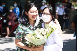 Một phụ huynh tặng hoa chúc mừng con gái hoàn thành tốt bài thi môn tổ hợp. (Ảnh: Phúc Tá/Vietnam+)