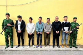 Hai đối tượng Trần Văn Binh và Dường Cắm Mằn đứng giữa 4 đối tượng người Trung Quốc. (Ảnh: TTXVN phát)