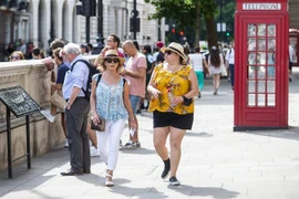 Người dân di chuyển trên đường phố tại London, Anh. (Ảnh: THX/ TTXVN)