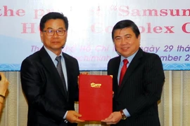 Chủ tịch Ủy ban Nhân dân Thành phố Hồ Chí Minh Nguyễn Thành Phong trao giấy chứng nhận cho dự án “Công ty TNHH điện tử SamSung HCMC CE Complex.” (Ảnh: Mạnh Linh/TTXVN)