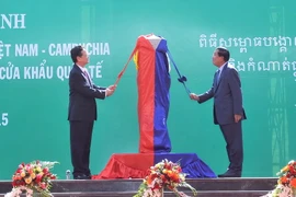 Thủ tướng Nguyễn Tấn Dũng và Thủ tướng Campuchia Hun Sen thực hiện nghi thức mở băng khánh thành Cột mốc 30 và đường nối hai trạm kiểm soát. (Ảnh: Trọng Đức/TTXVN)