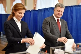 Tổng thống Ukraine Petro Poroshenko (phải) và phu nhân bỏ phiếu tại một địa điểm bầu cử ở Kiev. (Nguồn: AFP/TTXVN)