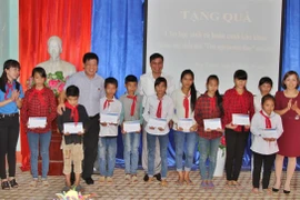 Đại diện đoàn công tác trao quà cho các em học sinh khó khăn vượt khó ở trường trung học cơ sở Hợp Thành. (Ảnh: Lê Sơn/Vietnam+)