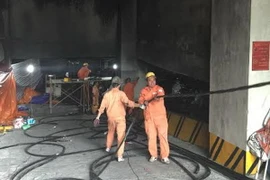 Công nhân kéo cáp điện vào tòa nhà CT4B và CT4C. (Ảnh: Mạnh Khánh/Vietnam+)