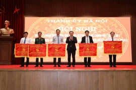 Bí thư Thành ủy Hà Nội Vương Đình Huệ trao tặng Cờ thi đua của Ban Thường vụ Thành ủy Hà Nội cho các Đảng bộ đạt thành tích xuất sắc trong nhiệm kỳ 2015/2019. (Ảnh: Văn Điệp/TTXVN)