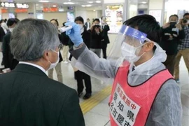 Kiểm tra thân nhiệt để ngăn chặn sự lây lan của dịch COVId-19 tại Nagoya, Nhật Bản, ngày 29/4/2020. (Ảnh: Kyodo/TTXVN)