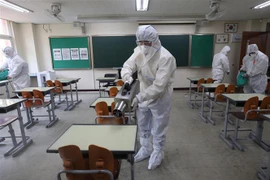 Nhân viên kiểm dịch phun thuốc khử trùng tại trường học ở Seoul, Hàn Quốc ngày 11/5/2020 nhằm ngăn chặn sự lây lan của COVID-19. (Ảnh: Yonhap/TTXVN)