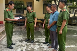 Lực lượng công an đọc lệnh bắt giữ khẩn cấp ông Ngô Văn Cao, Giám đốc Công ty TNHH Thương mại Hưng Cao. (Ảnh: TTXVN phát)