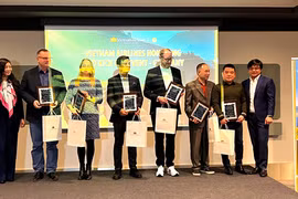 Bà Phạm Thị Nguyệt, Trưởng Ban Tiếp thị và Bán sản phẩm của Vietnam Airlines (ngoài cùng bên trái) và ông Cao Chinh Miên (ngoài cùng bên phải) vinh danh các đại lý của Vietnam Airlines. (Ảnh: Phương Hoa/TTXVN)