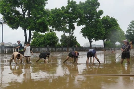 Người dân dọn dẹp vệ sinh sau khi nước rút tại Lào Cai. (Ảnh: Hồng Ninh/TTXVN)