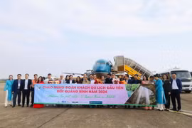 Lãnh đạo Sở Du lịch tỉnh Quảng Bình tặng hoa những du khách đến tỉnh đầu tiên trong năm 2024. (Ảnh: Công Thành/TTXVN)