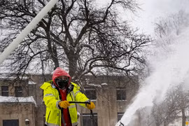 Công nhân dọn tuyết tại Des Moines, bang Iowa, Mỹ. (Ảnh: AFP/TTXVN)