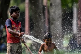 Trẻ em chơi đùa với nước trong ngày nắng nóng tại New Delhi, Ấn Độ, ngày 31/5. (Ảnh: AFP/TTXVN)