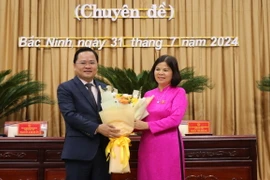 Bí thư Tỉnh ủy Bắc Ninh Nguyễn Anh Tuấn (bên trái) tặng hoa chúc mừng Chủ tịch Hội đồng Nhân dân tỉnh khóa XIX, nhiệm kỳ 2021-2026 Nguyễn Hương Giang. (Ảnh: Thái Hùng/TTXVN)