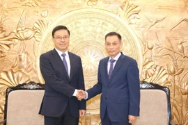 Bí thư Trung ương Đảng, Trưởng Ban Đối ngoại Trung ương Lê Hoài Trung tiếp Trợ lý Trưởng Ban Liên lạc Đối ngoại Trung ương Đảng Cộng sản Trung Quốc Triệu Thế Thông. (Ảnh: Phương Hoa/TTXVN)