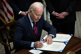 Tổng thống Mỹ Joe Biden ký phê chuẩn một dự luật tại Nhà Trắng ở Washington DC. (Ảnh: AFP/TTXVN)