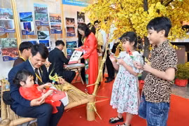 Các thiếu nhi kiều bào thích thú với những sản phẩm thủ mang đậm nét văn hóa truyền thống. (Ảnh: Xuân Khu/TTXVN)