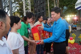 Ông Phạm Chí Tâm, Phó Chủ tịch Liên đoàn Lao động Thành phố Hồ Chí Minh tăng quà cho công nhân lao động. (Ảnh: Thanh Vũ/TTXVN)