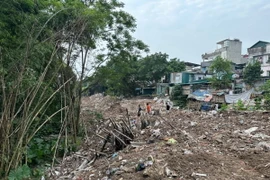 Rác phế thải và lều lán xây dựng trái phép khu vực bờ vở, bãi ven sông Hồng trước khi giải tỏa. (Ảnh: TTXVN phát)