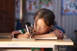 Sách giáo khoa tiếng dân tộc giúp học sinh có thể tiếp cận tri thức bằng tiếng mẹ đẻ. (Ảnh: TTXVN)