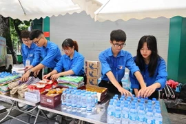 Tại các chốt trực, Thành đoàn đều bố trí điểm phục vụ miễn phí, cung cấp nước uống, đồ ăn nhẹ, quạt giấy, ô, áo mưa… cho người dân đến tiễn đưa Tổng Bí thư Nguyễn Phú Trọng. (Ảnh: Minh Đức/TTXVN)