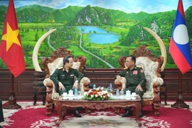 Thiếu tướng, giáo sư-tiến sỹ Lê Hữu Song báo cáo với Đại tướng Chansamone Chanyalath về những kết quả hợp tác thời gian qua. (Ảnh: Đỗ Bá Thành/TTXVN)