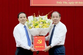Ông Tạ Văn Long, Phó Bí thư Thường trực Tỉnh ủy trao quyết định và tặng hoa chúc mừng tân Bí thư Huyện ủy Trấn Yên Trần Anh Tuấn. (Ảnh: TTXVN phát)