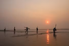 Ngư dân làng biển Hương Châu (xã Diễn Kim, huyện Diễn Châu, Nghệ An) đi cào ngao trên bờ biển. (Ảnh: Xuân Tiến/TTXVN)