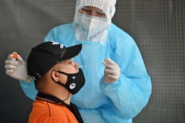 Nhân viên y tế lấy mẫu xét nghiệm COVID-19 cho người dân tại Bangkok, Thái Lan. (Ảnh: AFP/TTXVN)