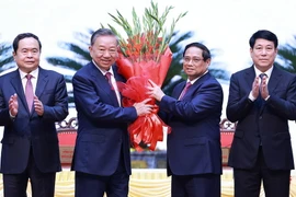 Ủy viên Bộ Chính trị, Thủ tướng Phạm Minh Chính thay mặt các đồng chí lãnh đạo chủ chốt, lãnh đạo cấp cao của Đảng, Nhà nước tặng hoa chúc mừng đồng chí Tô Lâm được bầu giữ chức Tổng Bí thư khóa XIII. (Ảnh: Dương Giang/TTXVN)