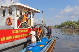 Người dân ở xã Biển Bạch, huyện Thới Bình, vui mừng vì được cung cấp nước ngọt sinh hoạt. (Ảnh: Huỳnh Anh/TTXVN)