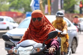 Người dân di chuyển trên đường phố dưới trời nắng nóng tại Bhopal, bang Madhya Pradesh, Ấn Độ. (Ảnh: THX/TTXVN)