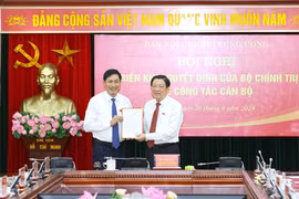 Ông Phan Đình Trạc, Ủy viên Bộ Chính trị, Bí thư Trung ương Đảng, Trưởng Ban Nội chính Trung ương trao Quyết định của Bộ Chính trị cho ông Nguyễn Hữu Đông. (Ảnh: Phương Hoa/TTXVN)