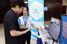 Các đại biểu tìm hiểu các giải pháp AI cho doanh nghiệp được trưng bày tại một hội thảo. (Ảnh: Tiến Lực/TTXVN)