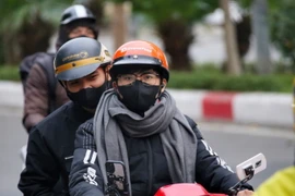 Người dân Hà Nội mặc thêm áo rét khi đi đường. (Ảnh: Tuấn Đức/TTXVN)