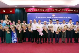 Ông Nguyễn Hồ Hải, Phó Bí thư Thường trực Thành ủy Thành phố Hồ Chí Minh tặng hoa chúc mừng các Ủy viên Ủy ban Mặt trận Tổ quốc Việt Nam thành phố khóa XI được hiệp thương bổ sung tại Hội nghị. (Ảnh: Xuân Khu/TTXVN)