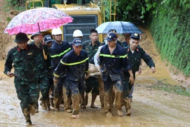 Lực lượng chức năng khẩn trương đưa các nạn nhân trong vụ sạt lở đi cấp cứu. (Ảnh: Đức Thọ/TTXVN)