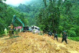 Cán bộ chiến sỹ Bộ Chỉ huy Quân sự tỉnh và Công an tỉnh Hà Giang tập trung tìm kiếm nạn nhân bị vùi lấp trong vụ tai nạn. (Ảnh: Thế Đồng/TTXVN phát)