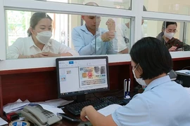 Người dân đến đăng ký tham gia bảo hiểm y tế tại Bảo hiểm Xã hội huyện Lục Yên, tỉnh Yên Bái. (Ảnh: Việt Dũng/TTXVN)